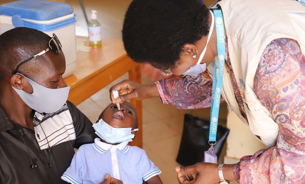 Vaccination contre la polio au Burkina Faso : agent de santé administrant un vaccin à un enfant