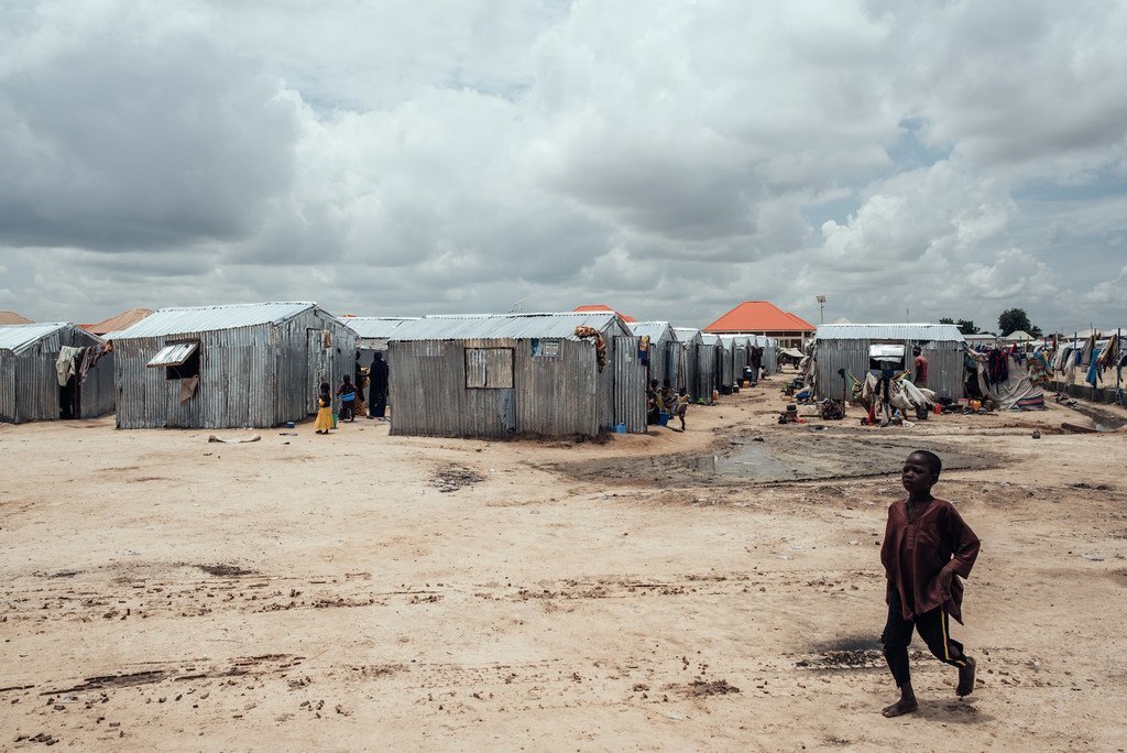 Enfant devant des abris dans un camp de déplacés à Maiduguri, État de Borno, Nigéria
