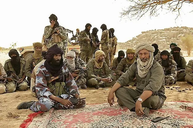 Combattants touaregs et arabes en réunion sous un arbre dans le désert