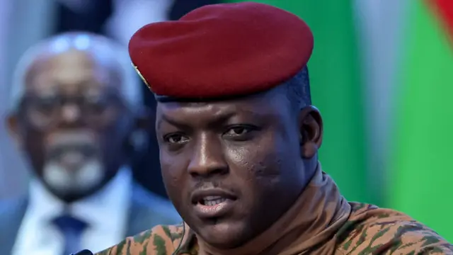 Portrait du capitaine Ibrahim Traoré en tenue militaire beige et béret rouge.