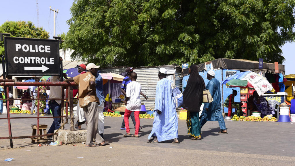 À Karang, au Sénégal, des voyageurs franchissent un poste de contrôle policier pour se rendre en Gambie